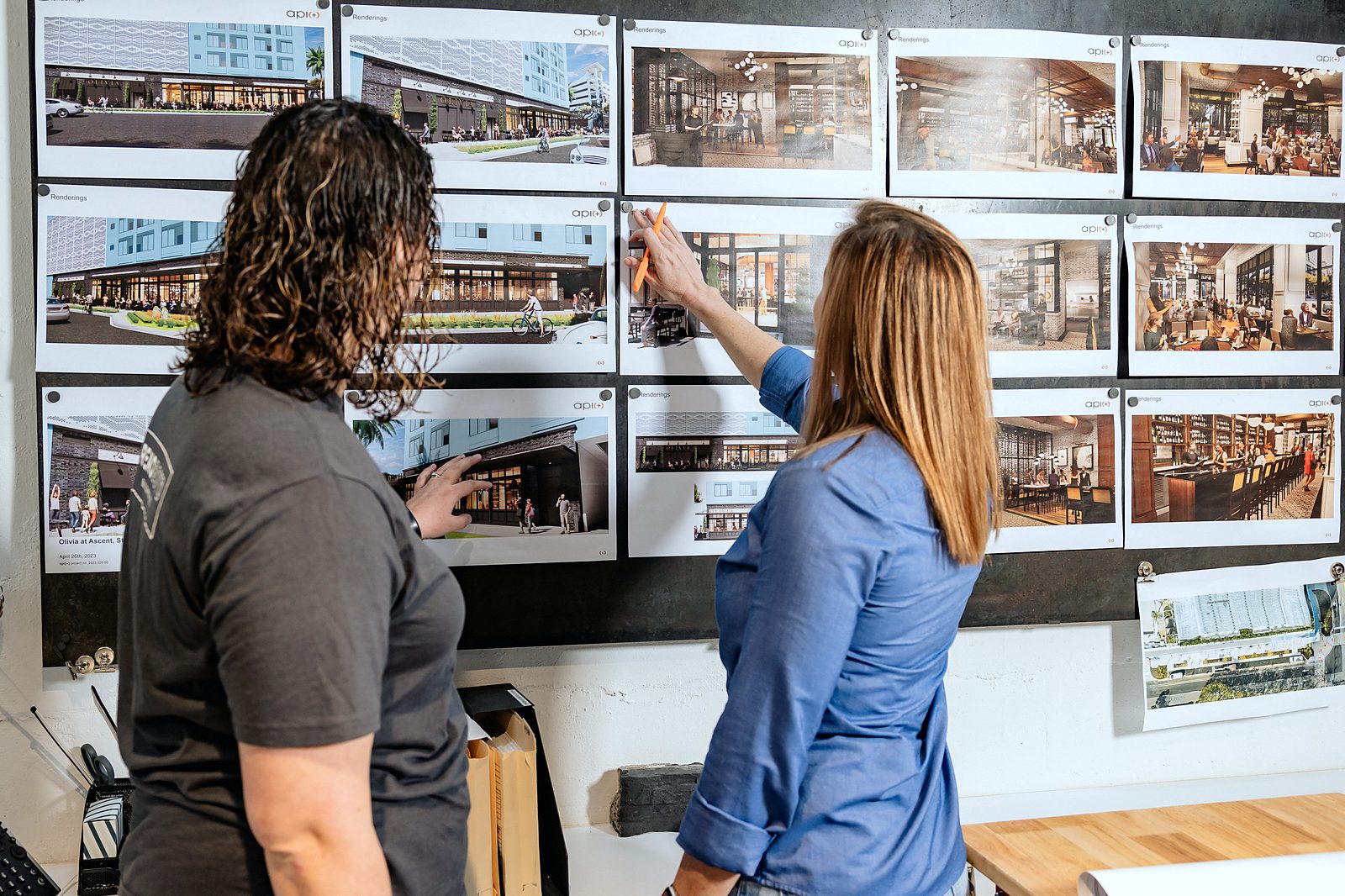 Reno Boyd Building Co. team members reviewing project renderings and plans pinned to a wall in the office