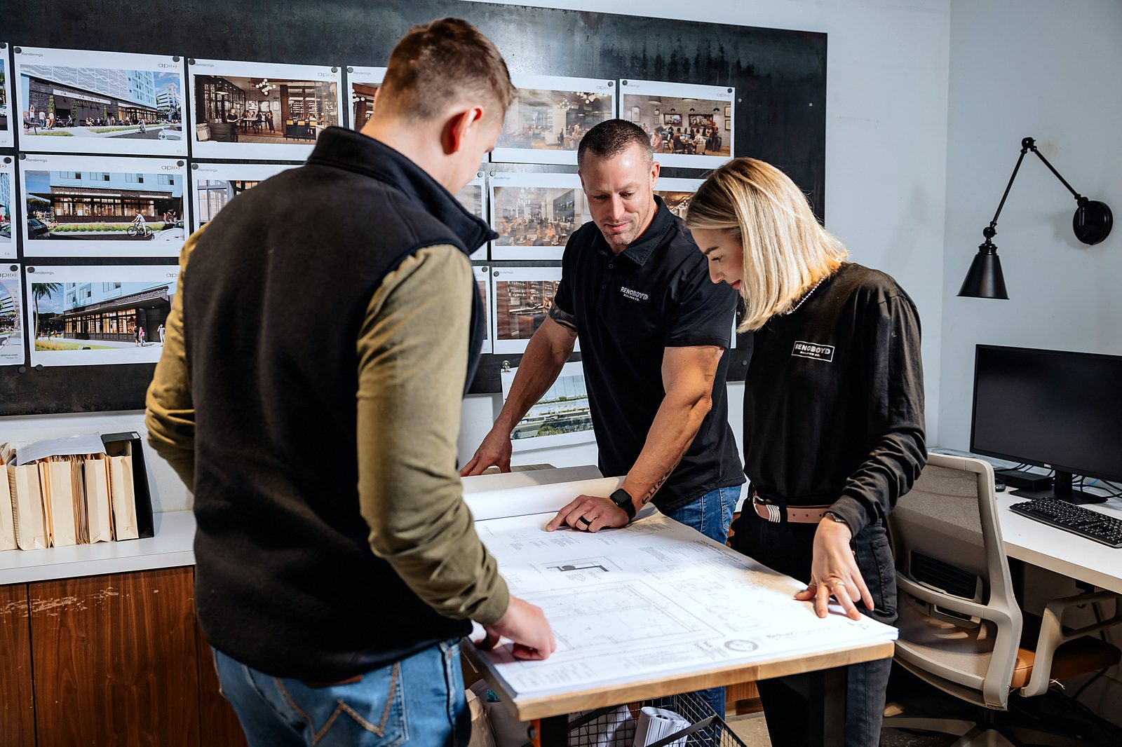 Reno Boyd Building Co. project team reviewing construction drawings at a plan table in the Tampa office